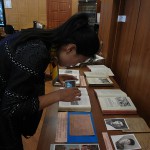 Сотрудник Хэйлунцзянского архива Сунь Лэй изучает экспонаты выставки.